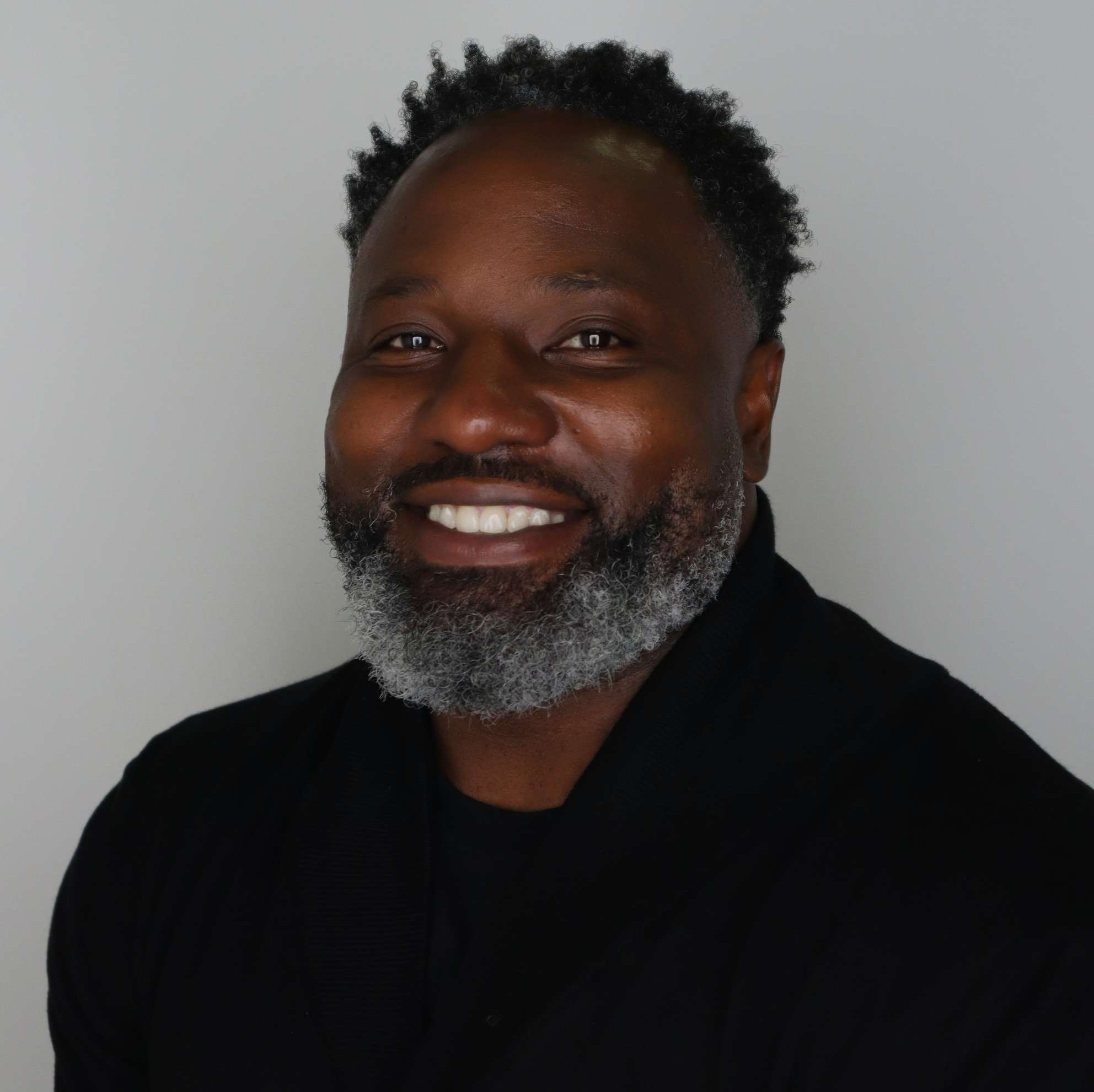 Professional headshot of Dr. Jonathean Reese smiling in a black shirt